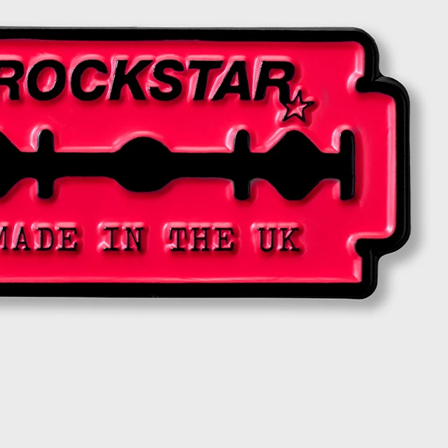 Enamel pin of a pink razor with text reading: Rockstar. Made in the UK.